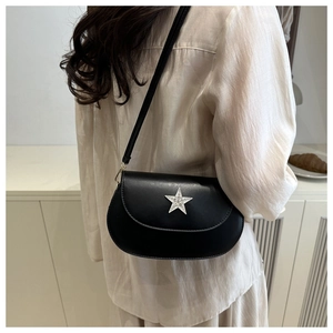 Lifestyle view of a black saddle crossbody bag featuring a silver star ornament with crystals