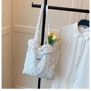 Détail du sac fourre-tout en toile blanche à imprimé floral et étiquette de mode