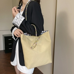 Minimalist canvas tote bag in mustard yellow with colorful beaded shoulder strap detail