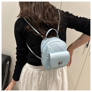 Detail of light blue quilted mini backpack with chain strap and silver twist lock