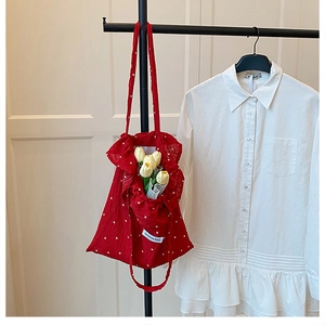 Détail du sac cabas floral rouge avec bords volantés et étiquette mode en tissu