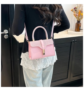 Pink sequined small square bag shown as a crossbody on a model for scale and style