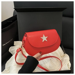 Detail of red faux leather saddle bag with silver rhinestone star and adjustable strap