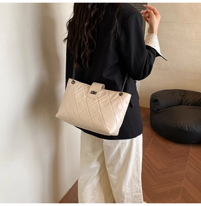 Classic quilted shoulder bag with gold chain strap and metal turn-lock on a model