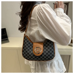 Détail du sac croissant en jacquard avec motif monogramme M et boucle en métal doré