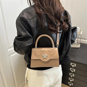 Sac bandoulière beige chic avec étoile en strass présenté dans une scène de style