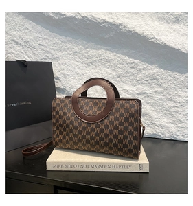 Sac à main rétro avec poignée circulaire et imprimé de lettres sur fond de roche