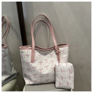 Detail of white tote bag set featuring pink bow prints and matching inner pouch