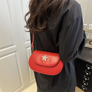 Red leather crossbody bag with silver star diamond ornament on a black outfit