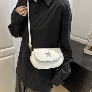 Minimalist white faux leather saddle bag with star rhinestone detail on black shirt