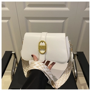 Detail of white saddle bag with golden oval buckle and geometric woven wide strap