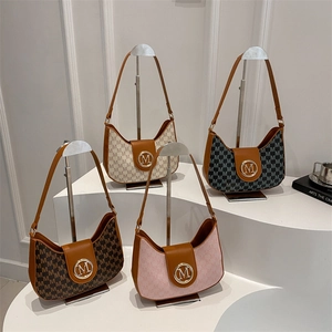 Sacs hobo croissants chics en divers monogrammes avec logo M doré sur présentoir