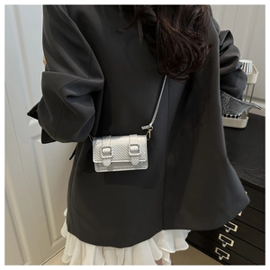 Detail of silver crossbody bag with carbon fiber texture and metallic shoulder strap