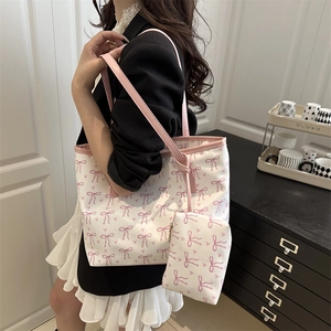 Pink bow printed tote bag with matching pouch shown in a stylish home setting