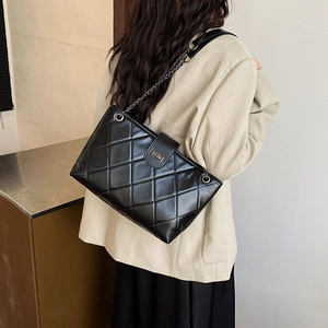 Grande borsa a spalla trapuntata nera con chiusura argento mostrata su una modella