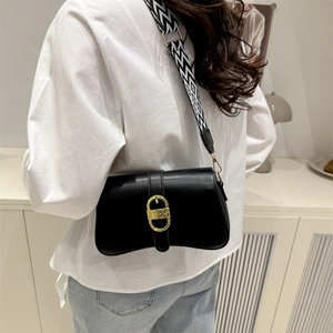 Fashionable black crossbody bag with gold buckle and geometric strap in modern setting