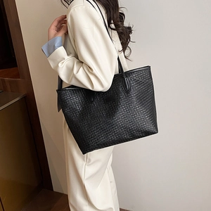 Chic black woven leather tote bag for women shown as a stylish large shoulder bag on model