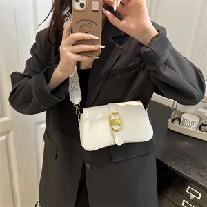 White square shoulder bag with gold oval buckle and patterned woven strap on a model