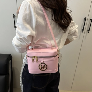 Pink PU leather box bag with gold M-logo and adjustable strap worn by a model