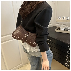Detail of dark brown faux-croc baguette bag with gold studs and buckle design