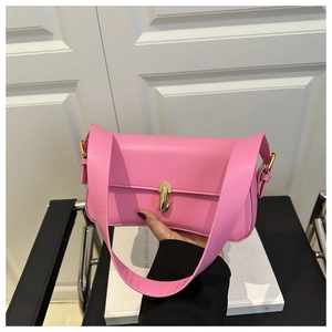 Close-up of pink minimalist underarm bag featuring a golden turn-lock metal clasp