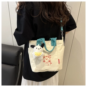 Detail of canvas tote bag featuring cute cartoon bear print and blue crossbody strap