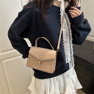 Sac bandoulière carré abricot élégant avec fermoir doré et texture en cuir lisse