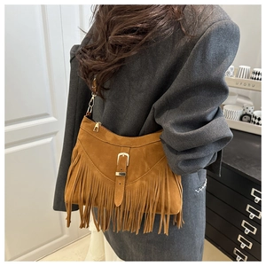 Détail du sac hobo en daim marron avec de longues franges et une chaîne dorée
