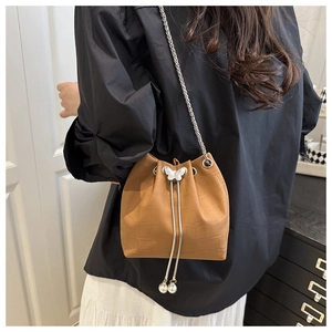 Detail of brown faux leather bucket bag with crocodile texture and silver butterfly buckle