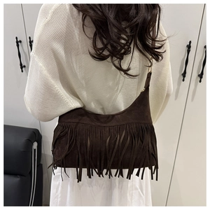 Detail of dark brown suede crescent bag with long fringes in bohemian style