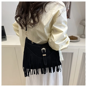 Détail du sac cabas en daim noir avec franges pendantes et boucle en métal doré