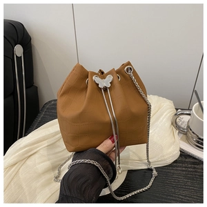 Detail of brown croc-embossed bucket bag with silver butterfly clasp and pearl drawstring
