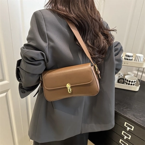 Classic brown leather underarm bag with gold oval twist lock for a stylish urban look