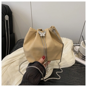 Detail of beige crocodile pattern bucket bag with pearl drawstring and silver butterfly buckle