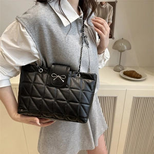 Chic black quilted tote bag with silver bow detail and chain strap for women
