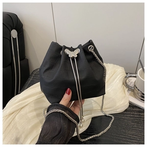 Close-up of black crocodile pattern bucket bag with silver butterfly buckle and chain