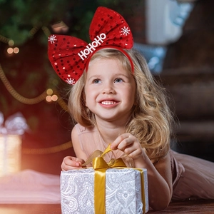 Christmas headband with red sequined bow and white snowflake pattern on a young girl