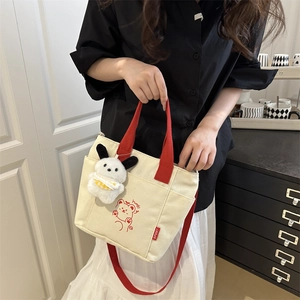 Borsa tote in tela beige con manici rossi, stampa orso e ciondolo a forma di cane