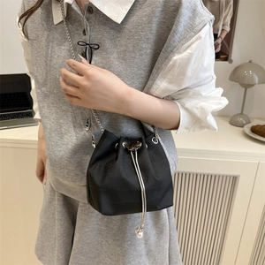 Fashionable black textured bucket bag with silver chain strap and pearl drawstring detail