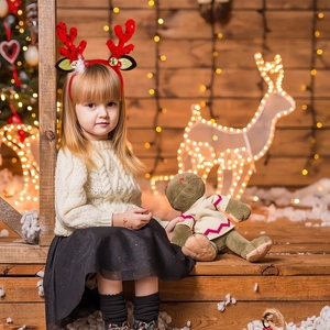 Close-up of a festive sequined reindeer headband with Santa and gold bells for kids