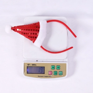 Detailed view of lightweight sequined Christmas hat headband weighing 19g on scale