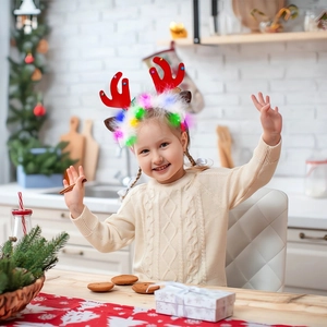 Close-up of a child wearing a glowing Christmas reindeer headband with LED lights