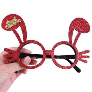 Detail of red glitter Christmas glasses with bunny ears and golden Merry Christmas text