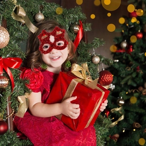 Red glitter Christmas eye mask with Merry Christmas text shown in a festive gift scene