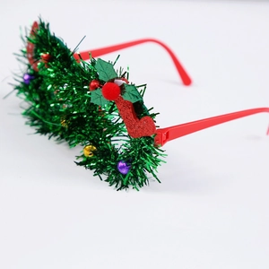 Close-up of Christmas decorative glasses with green tinsel and red stockings