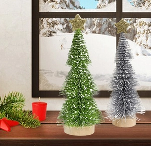 Close-up of mini snow-tipped Christmas trees with gold star toppers and wooden bases