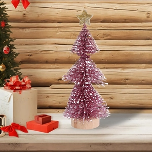 Detailed view of a mini rose pink Christmas tree with snow glitter and a golden star top
