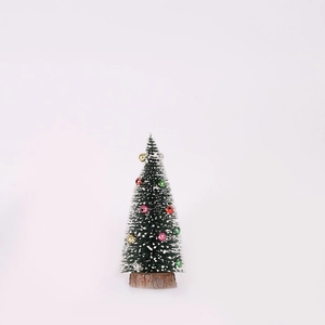 Macro detail of mini flocked Christmas tree with colorful ornaments and a natural wooden base