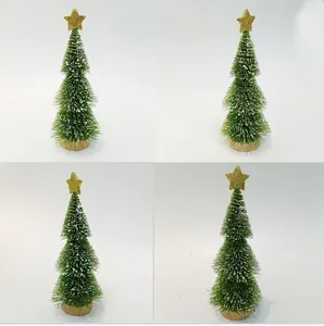 Close-up of mini snowy Christmas tree with golden star topper and wooden base