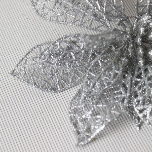 Close-up of hollowed-out silver glitter Christmas flower with shimmering mesh texture